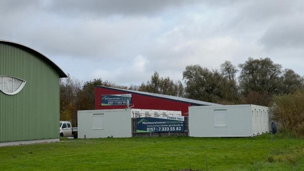 a building with four garage stalls in a field at Monteurzimmer Glückstadt in Glückstadt