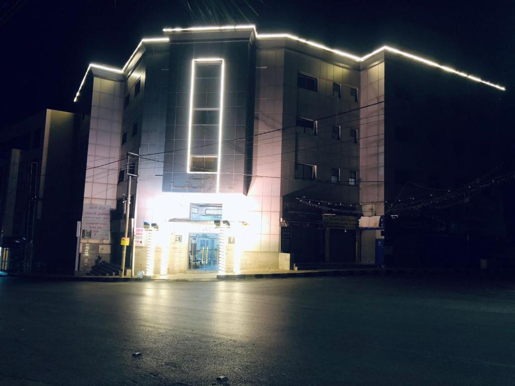 a building with lights on it at night at الأحفاد للشقق الفندقية Al Ahfad Hotel Apartments in Şāfūţ