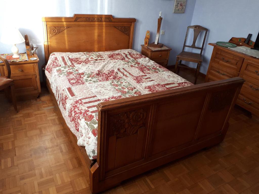 sypialnia z drewnianym łóżkiem z kołdrą w obiekcie Chambre de charme chez l'habitant à la campagne w mieście Niederhergheim