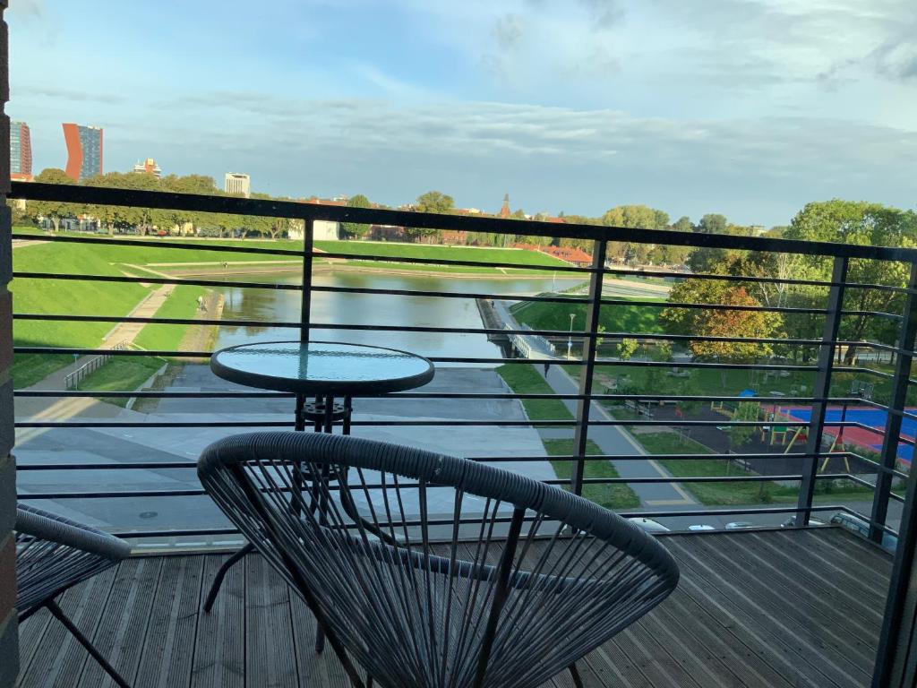 um pátio com uma mesa e cadeiras numa varanda em Riverside apartment self check-in em Klaipėda