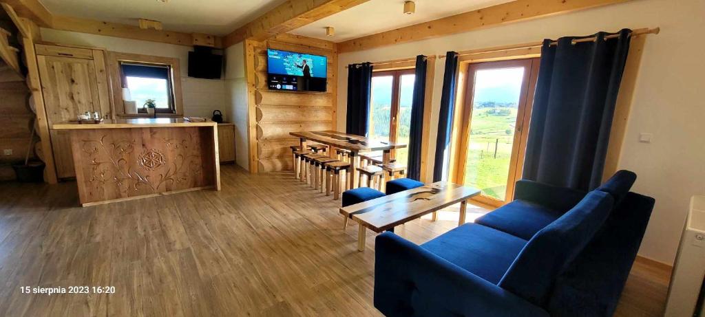 a living room with a blue couch and a table at NOWA CHATA in Bustryk