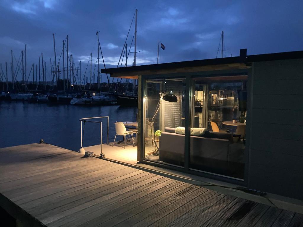 a small building on a dock next to a marina at Houseboat De Amstel in Monnickendam