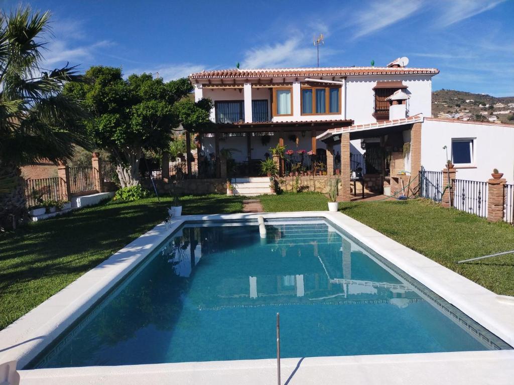 una piscina frente a una casa en Paraje El Pozo en Málaga