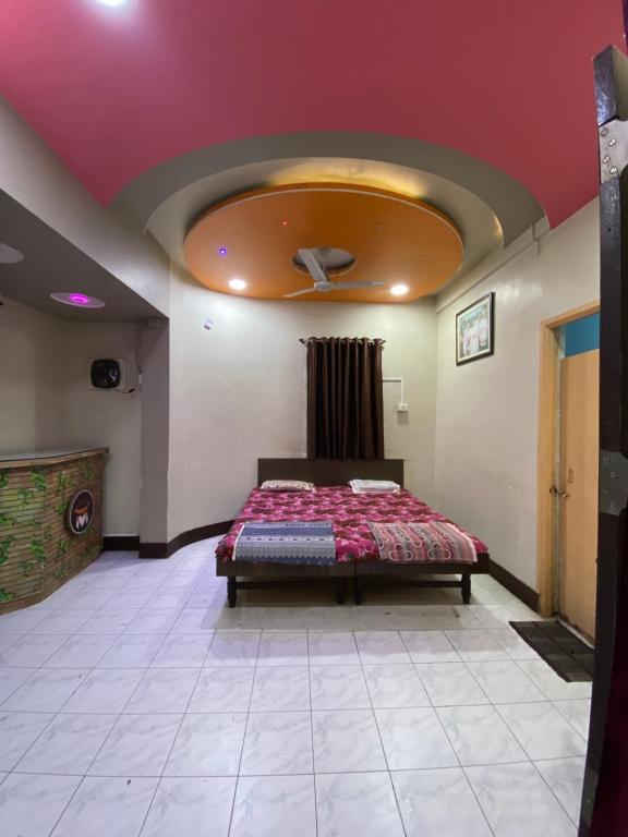 ein Schlafzimmer mit einem Bett in einem Zimmer mit einer Decke in der Unterkunft MUKTAI LODGE in Solapur