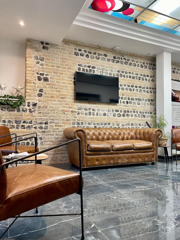 a living room with a couch and a brick wall at LA TOUR AUX CRABES près de la plage in Dieppe
