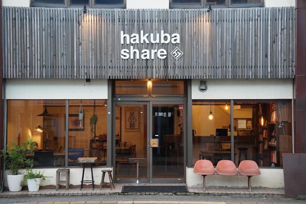 una tienda con dos sillas delante en 白馬シェア Hakuba share, en Hakuba