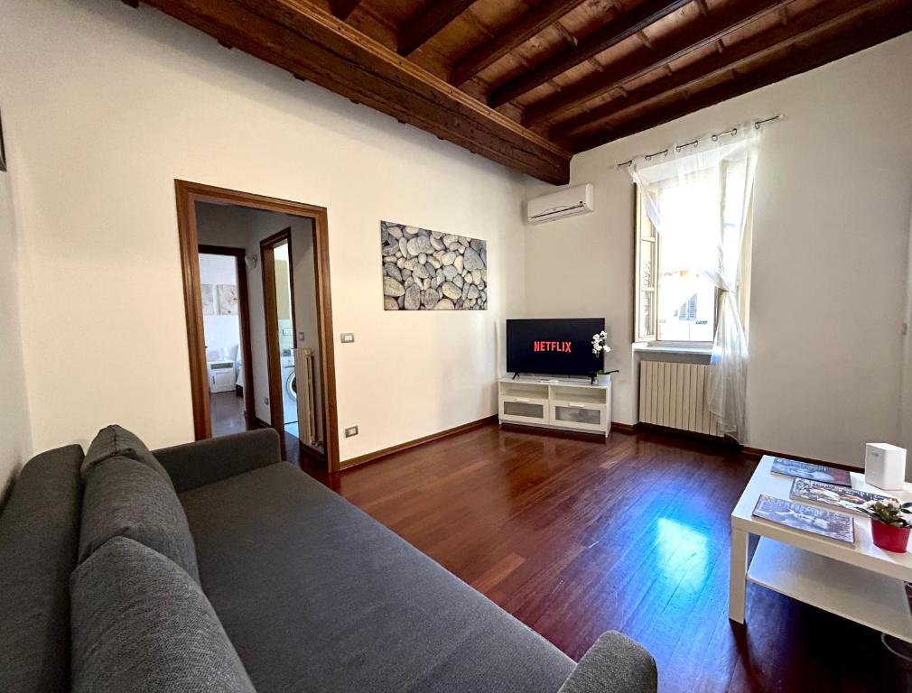 een woonkamer met een bank en een tv bij Appartamento Lagrange - Torino Centro in Turijn