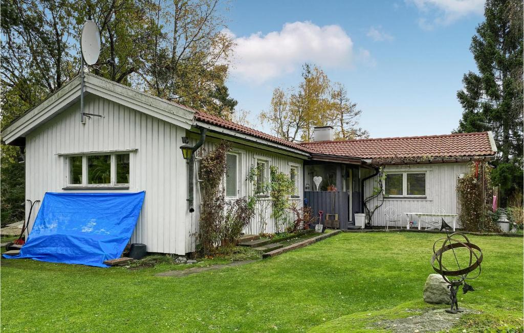 a white house with a blue tarp in the yard at Gorgeous Home In Huddinge With Wi-fi in Huddinge