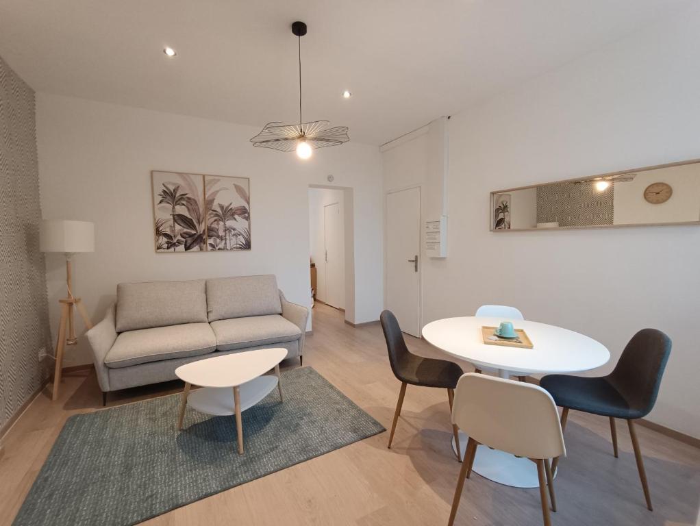un salon avec un canapé, une table et des chaises dans l'établissement Blue Horizon - Appartement 4 pers, à Dunkerque