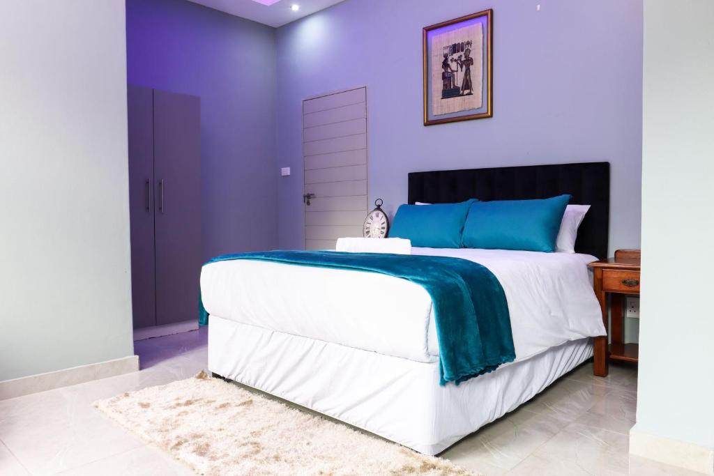 a bedroom with purple walls and a large bed at 235 LODGE in Durban