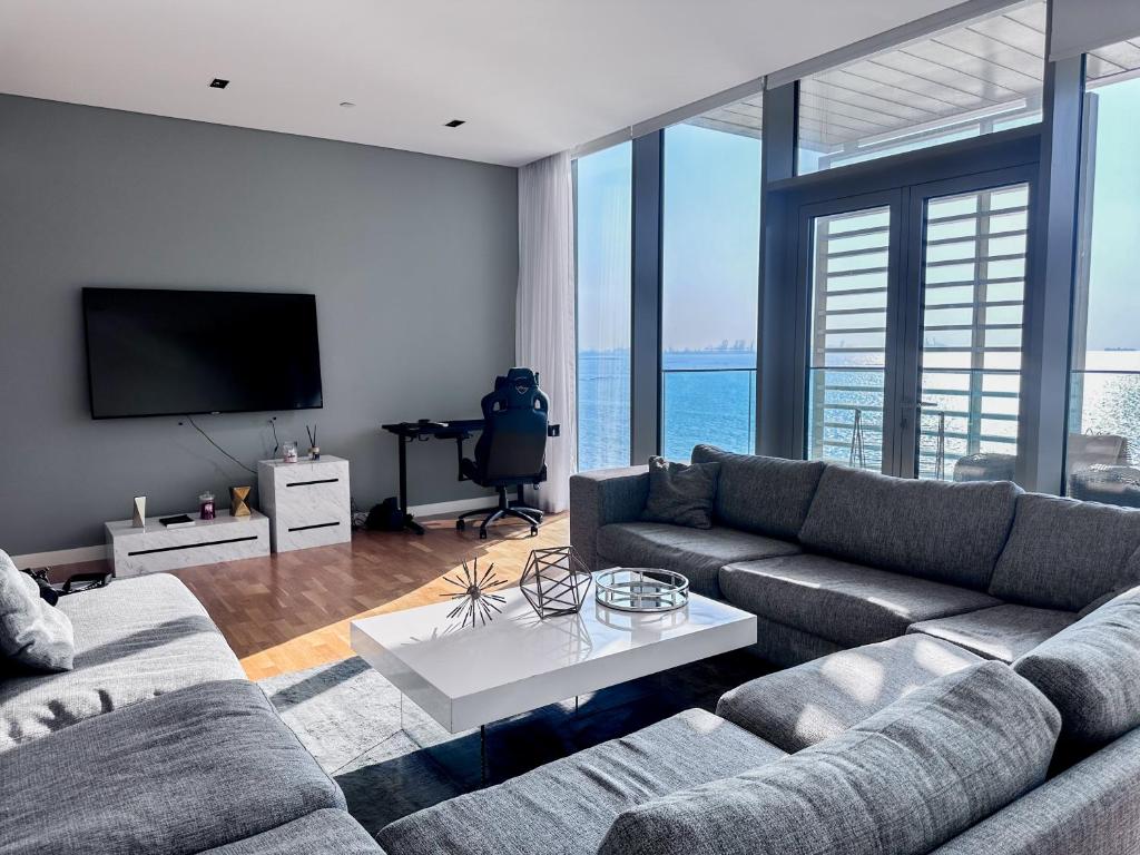 a living room with a couch and a tv at Fabulous full sea view 3br bluewaters Island in Dubai