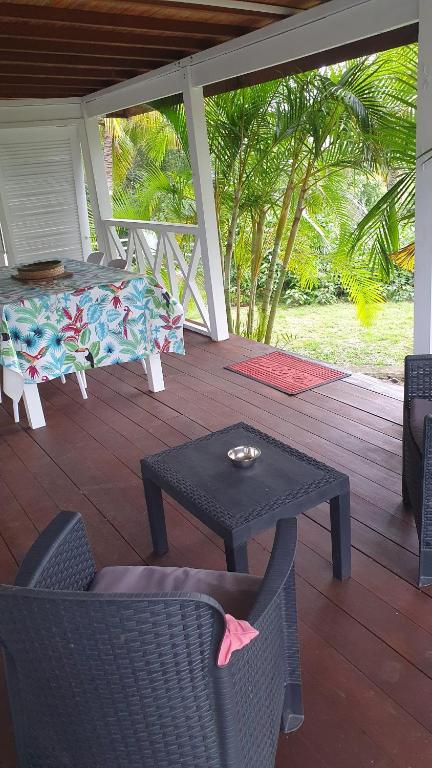 a patio with a table and chairs on a deck at Villa de Bois Blanc Strelitzia in Saint-Leu