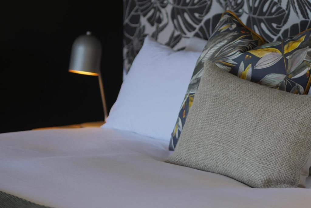 雷因恩道尔denBosch Cottages的卧室里有一张床，配有枕头和一盏灯