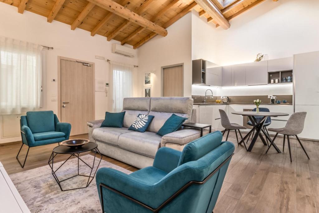 a living room with a couch and chairs and a kitchen at Veronetta Stunning Rooftop with Lift in Verona