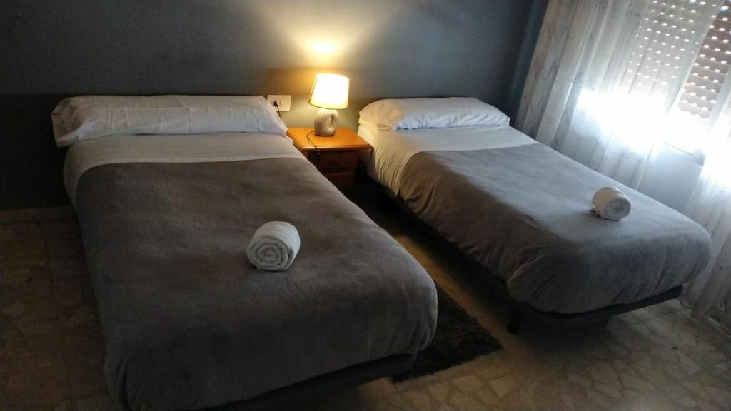 two beds in a hotel room with towels on them at El Refugio Bed & Breakfast in Villarrobledo