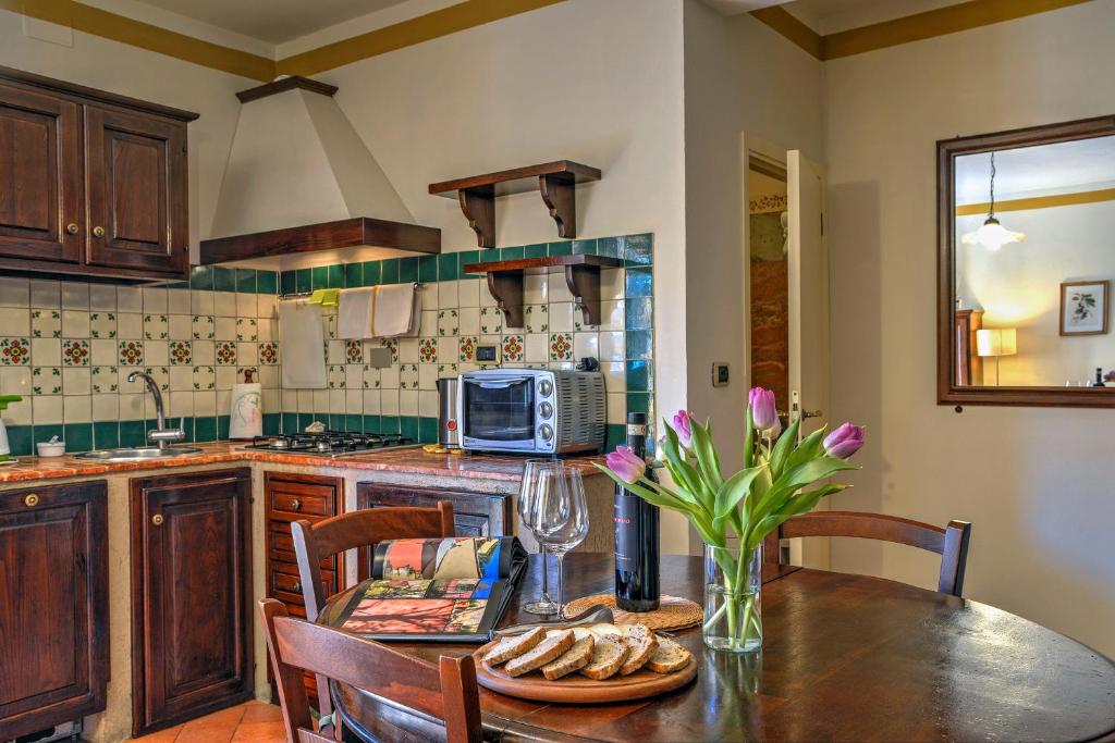 Borgo Grondaie في سيينا: مطبخ مع طاولة مع إناء من الزهور