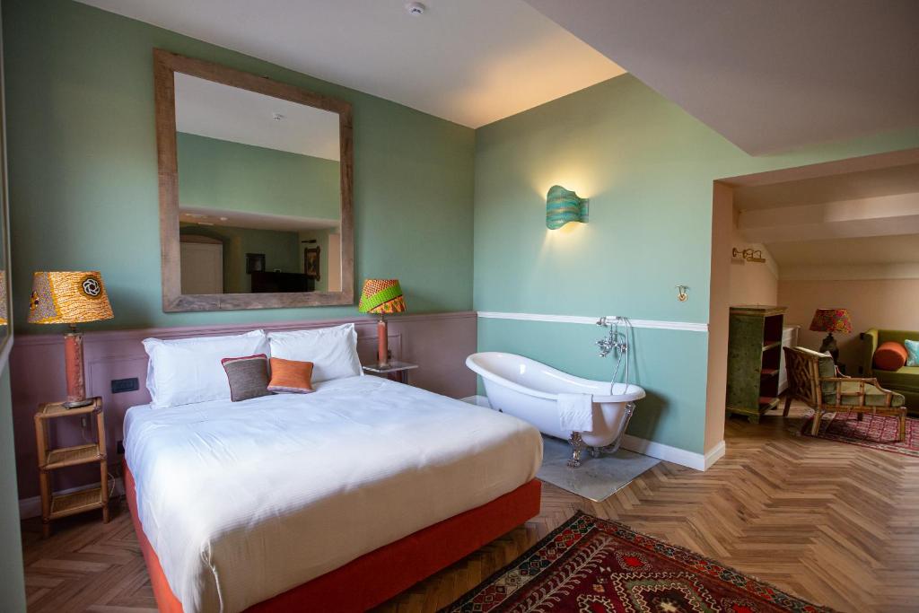 a bedroom with a bed and a mirror and a tub at Stella d'Italia in Florence