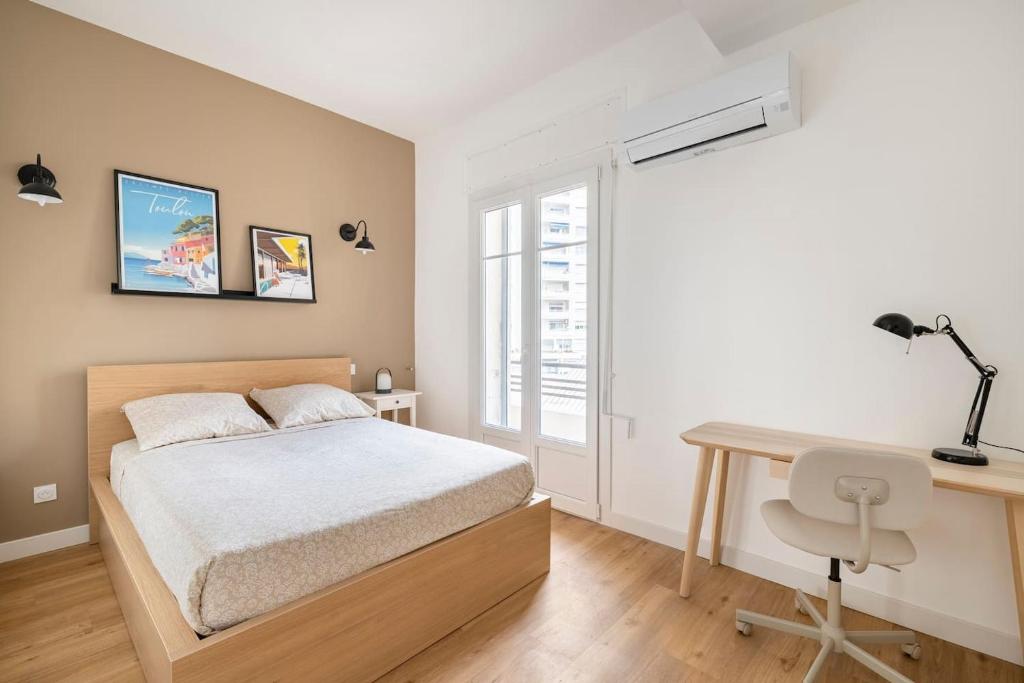 um quarto com uma cama, uma secretária e uma janela em les LOFTS de Saint Clair Un balcon à Toulon LOFT 4CH CLIM 8 PAX MAX em Toulon
