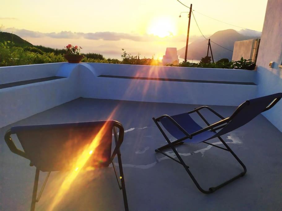 a chair on a balcony with the sunset in the background at Casa al tramonto...sunset lovers retreat in Lipari