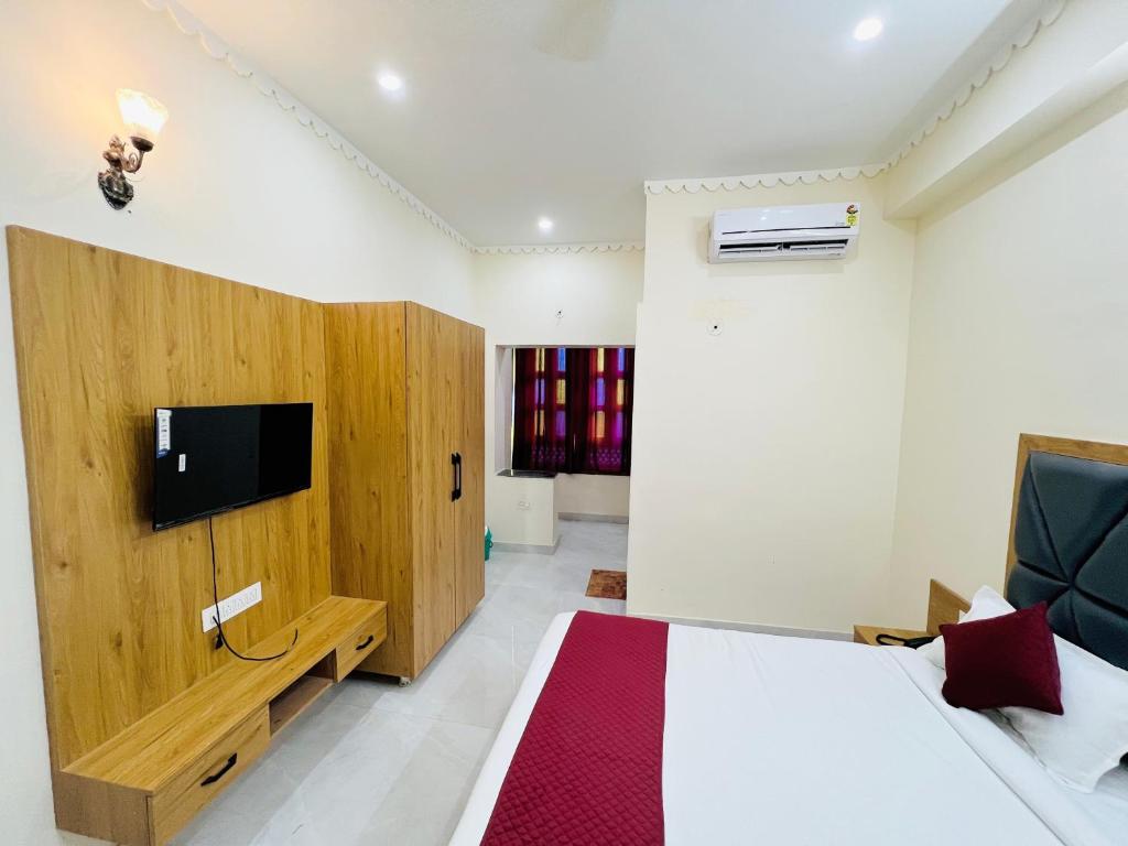 1 dormitorio con 1 cama y TV en la pared en Jai hari vilas, en Jodhpur