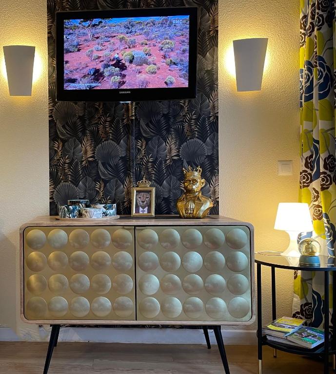a living room with a television on a wall at *A setting between Dordogne and swimming pool* in Argentat