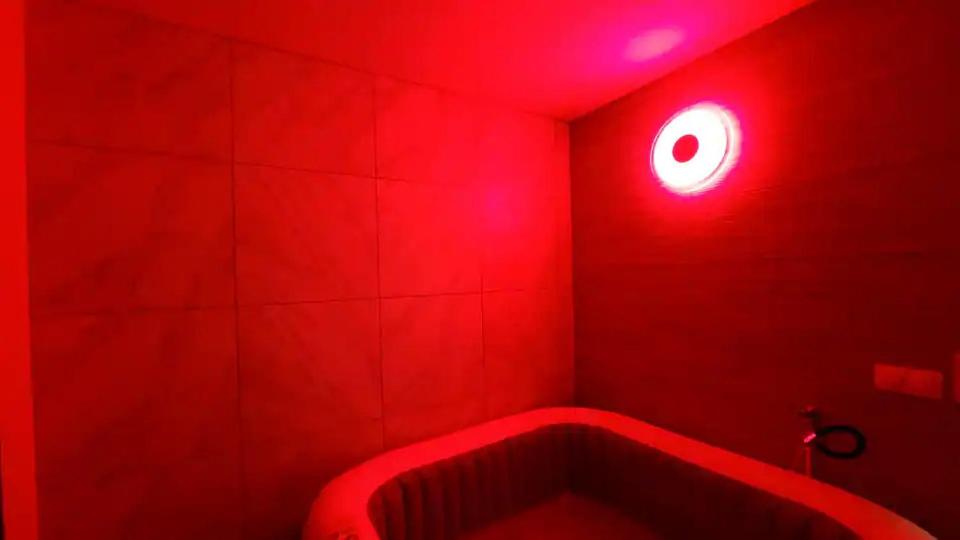 ein rotes Badezimmer mit einer Badewanne mit rotem Licht in der Unterkunft F2 Paris 10ème Gare du nord - Stade de France - Parking in Saint-Denis