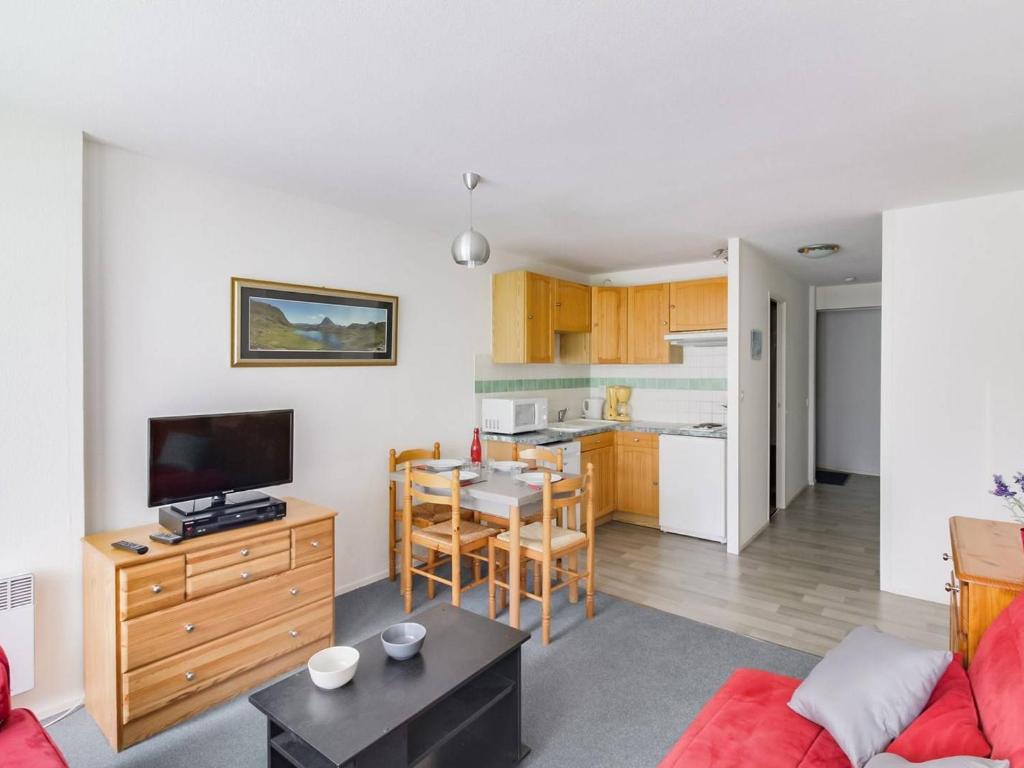 a living room with a red couch and a kitchen at Appartement La Mongie, 2 pièces, 5 personnes - FR-1-404-57 in La Mongie