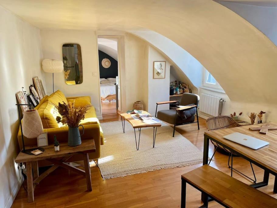 un salon avec un canapé jaune et une table dans l'établissement Magnifique appartement Paris 10ème, à Paris