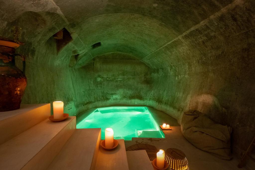 a green room with a swimming pool in a cave at Nohasi Palace Hotel & SPA in Noha