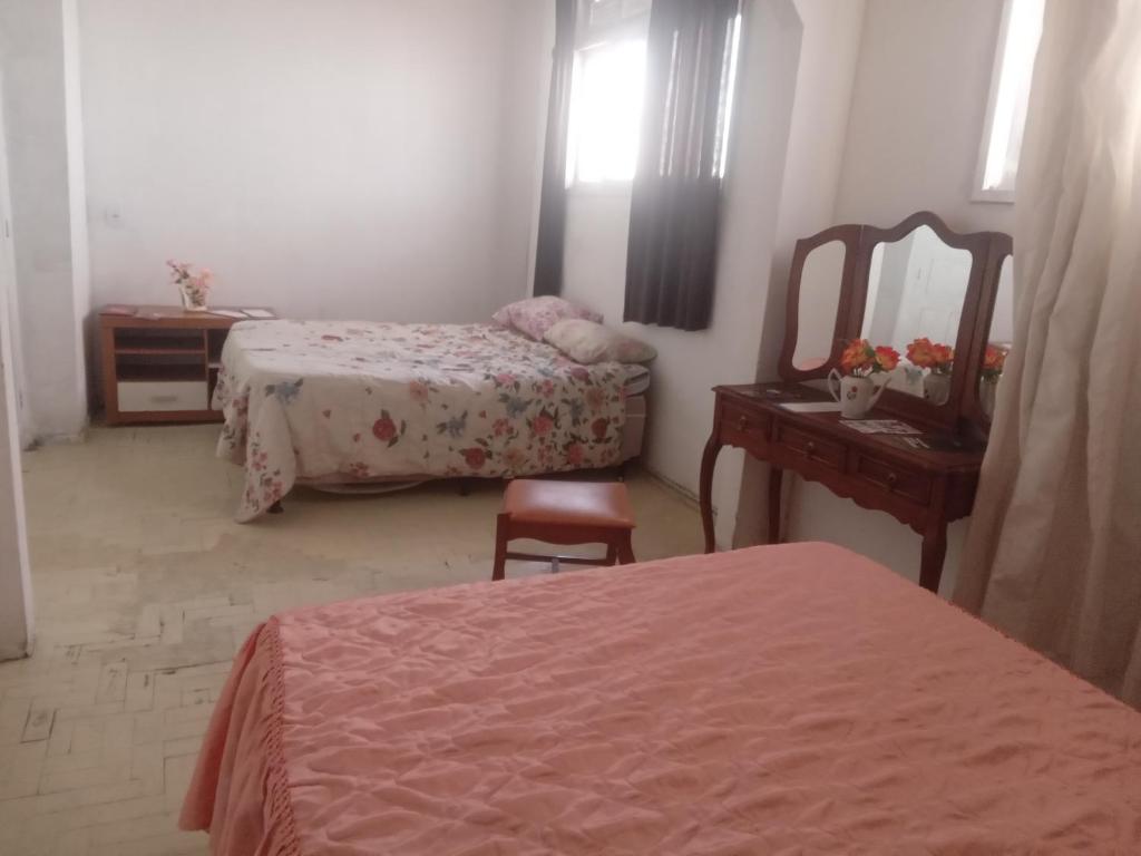 1 Schlafzimmer mit 2 Betten, einem Spiegel und einer Kommode in der Unterkunft Hostel Leonardo in Vitória