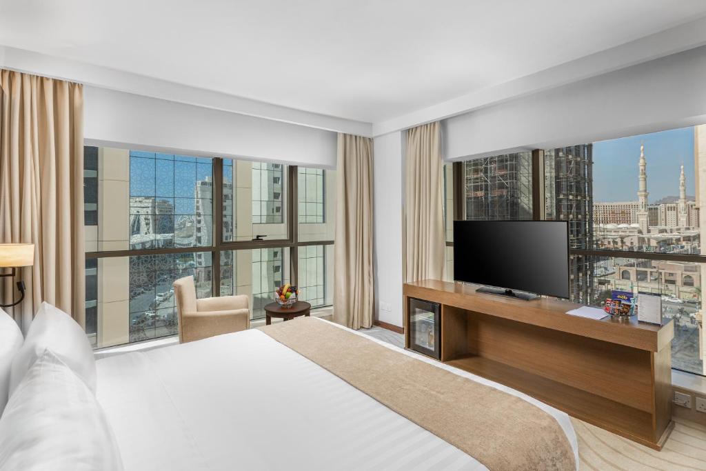 um quarto de hotel com uma cama e uma televisão em فندق جايدن-Jayden Hotel em Medina
