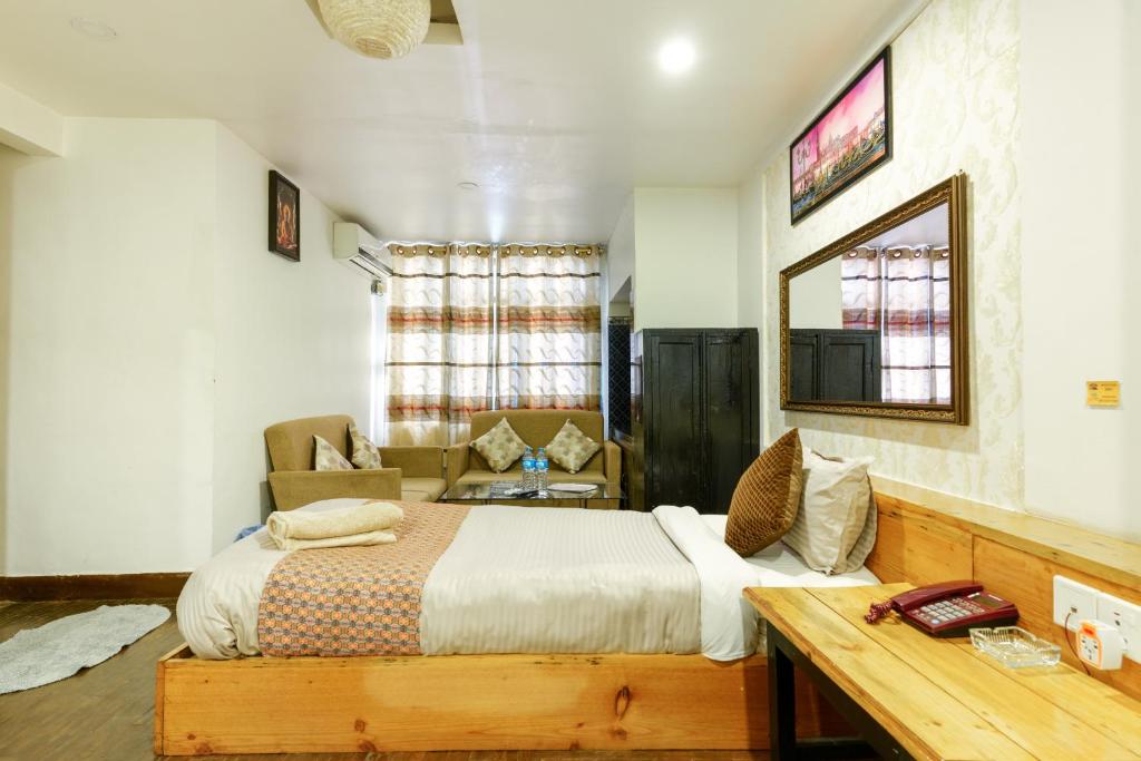 a bedroom with a bed and a desk in a room at Hotel Shree Tara in Kathmandu