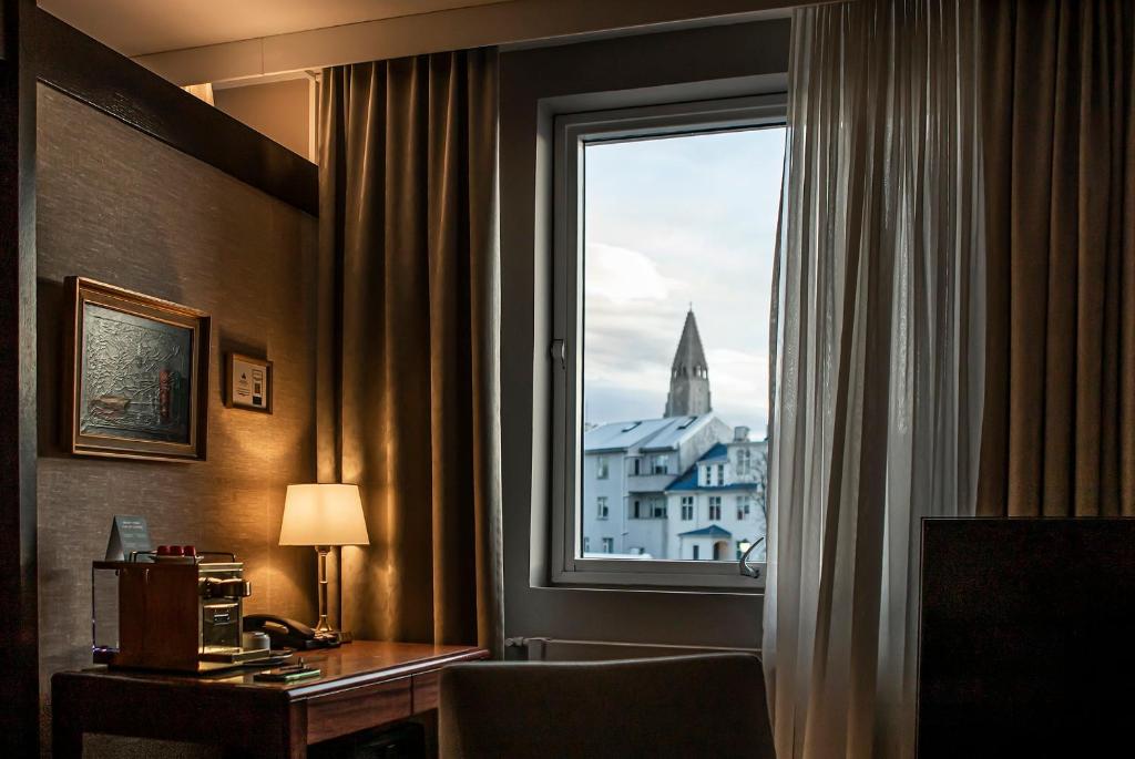 una camera d'albergo con finestra e scrivania con lampada di Hotel Holt - The Art Hotel a Reykjavik