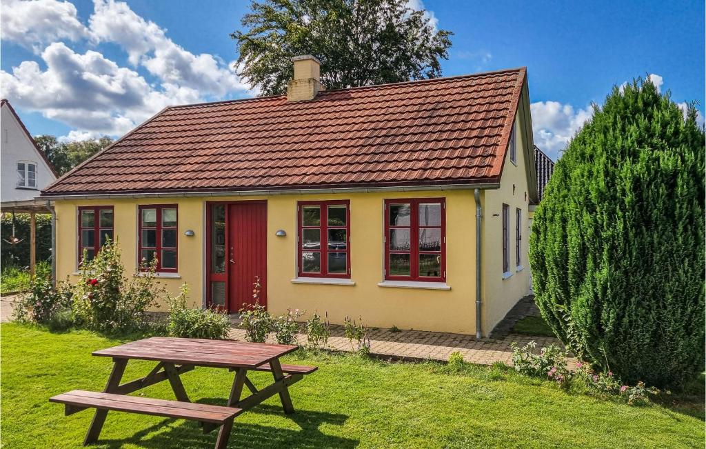 ein gelbes Haus mit einer roten Tür und einem Picknicktisch in der Unterkunft Lovely Home In Aabenraa With Kitchen in Aabenraa