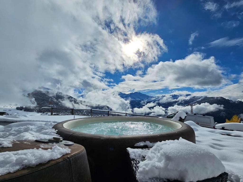 a hot tub in the snow with snow on the ground at B&B rooms within a modern family chalet with direct access to ski area in Verbier in Verbier