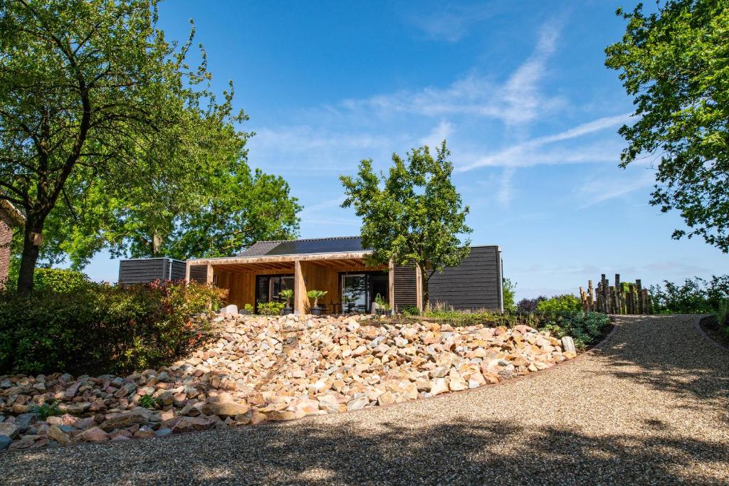 a home with a pile of rocks in front of a house at B&B De Groene Driehoek 'A' in Sint Agatha