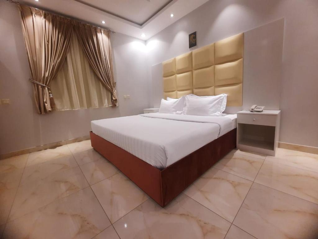 1 dormitorio con 1 cama grande en una habitación en العرين بارك للشقق المخدومة en Abha