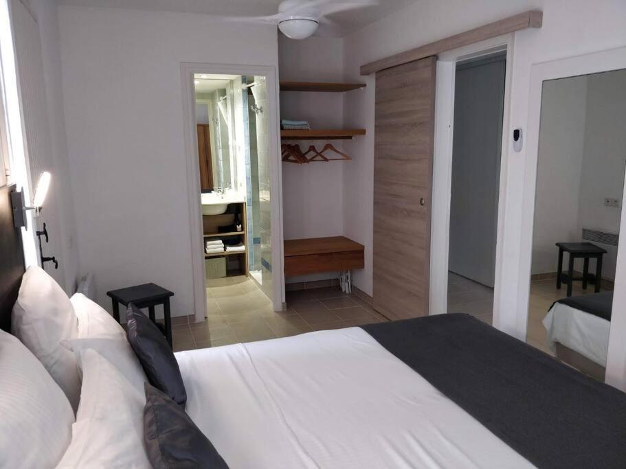 um quarto com uma grande cama branca e um corredor em St Raphaël 37m2, piscine, wifi, commerces mer 5mn à pieds em Saint-Raphaël