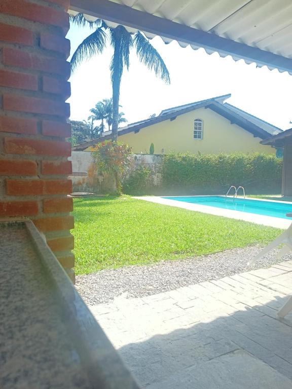 Blick auf einen Hof mit Pool und Haus in der Unterkunft Casa Riviera in Bertioga