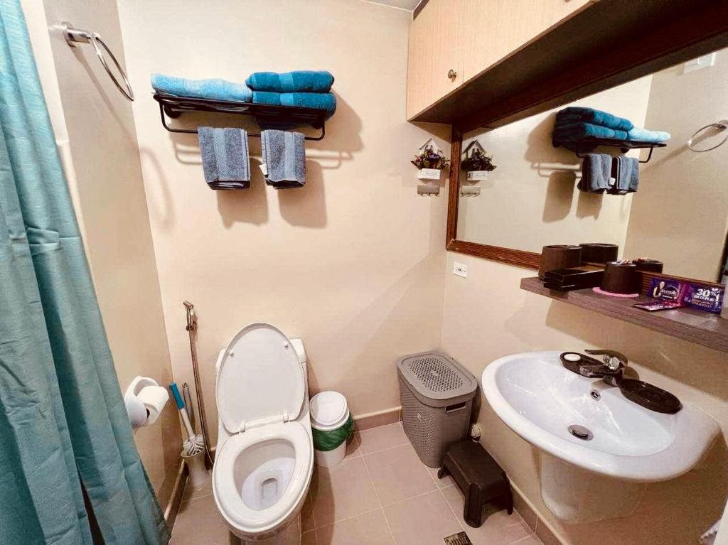 a bathroom with a toilet and a sink at Iloilo Staycation in Iloilo City