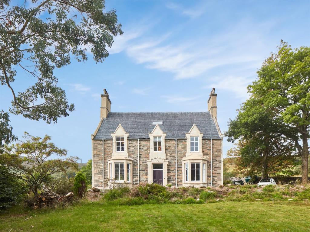 an old stone house with a large yard at Coillemore House in Balmacara