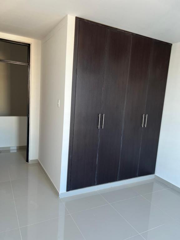 a large brown cabinet in a room with a door at Habitacion disponible in Valledupar
