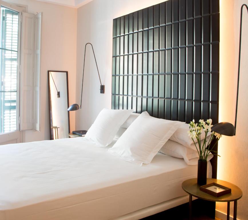 1 dormitorio con 1 cama blanca grande y cabecero negro en The Conica Deluxe Bed&Breakfast en Barcelona