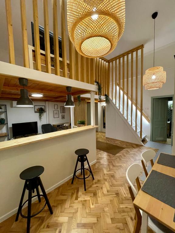 a kitchen and dining room with a table and stools at Bocskai Apartman in Szeged