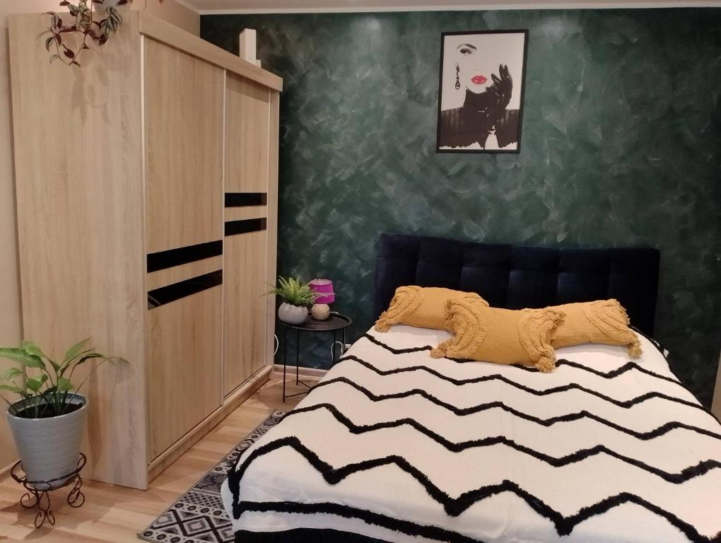 a bedroom with a bed and a green wall at Apartament Zibi in Zamość