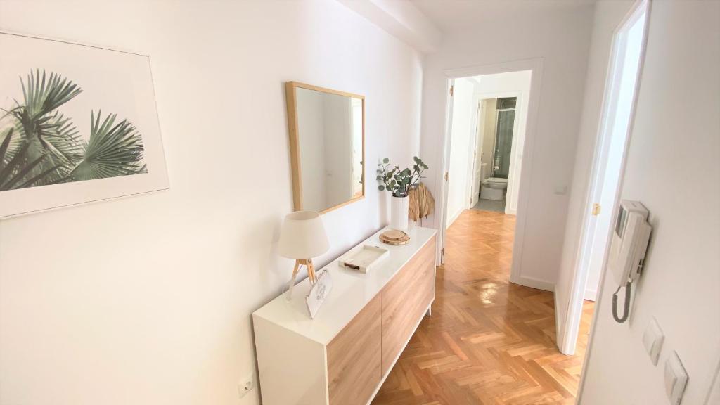 een witte kamer met een wastafel en een spiegel bij Apartamento Las Rozas centro con Parking incluido in Las Rozas de Madrid