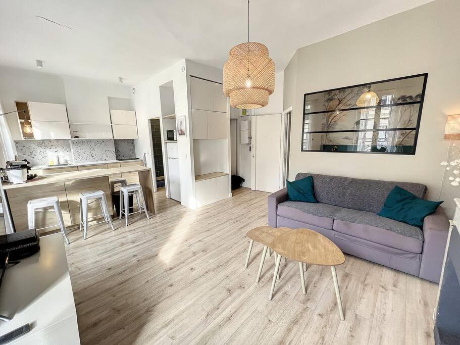Il comprend un salon avec un canapé violet et une cuisine. dans l'établissement PLACE - Appartement lumineux au coeur de la Joliette, à Marseille