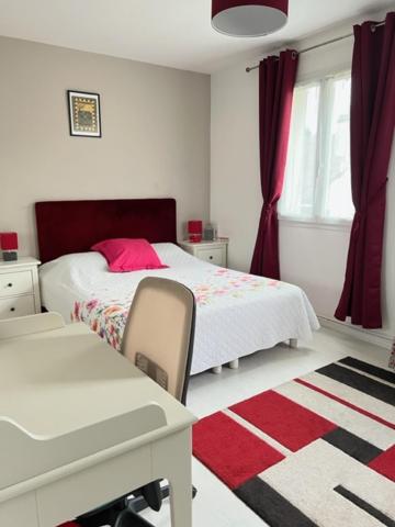 een witte slaapkamer met een bed, een bureau en een raam bij Spacieuse et cosy maison proche Paris in Brunoy