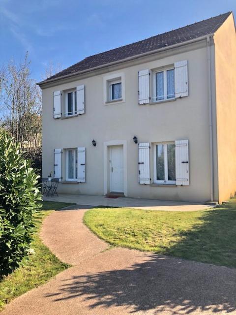 une grande maison blanche avec des fenêtres blanches et une allée dans l'établissement Spacieuse et cosy maison proche Paris, à Brunoy