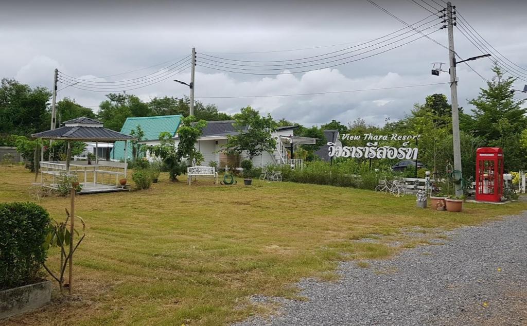 een huis met een bord dat pension naast een veld leest bij วิวธารารีสอร์ท (ViewThara Resort) in Ban Chak Phak Kut